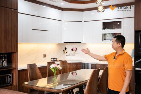 Tủ bếp Acrylic bóng gương phối màu trắng và nâu gỗ hiện đại sau khi thi công xong.